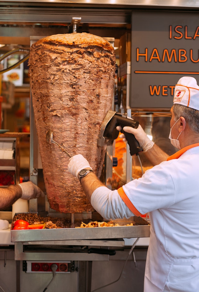 mężczyzna używający nóż do kebaba